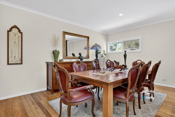 Inviting dining space featuring a large wooden table, classic furnishings, and abundant natural light.