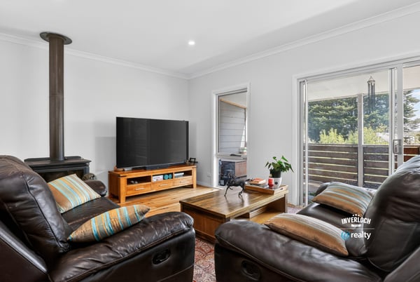 Discover a cozy living space featuring comfortable seating, a modern TV, and easy outdoor access.