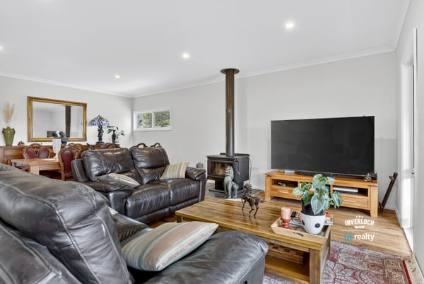 Spacious living area featuring a wood stove, ample seating, and an inviting atmosphere for gatherings.