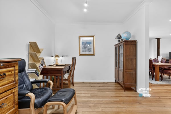 Bright, open workspace features natural light, wooden flooring, and functional design for productivity and comfort.