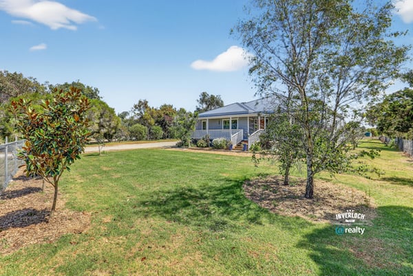 Discover this inviting home surrounded by lush greenery and ample outdoor space for relaxation and activities.