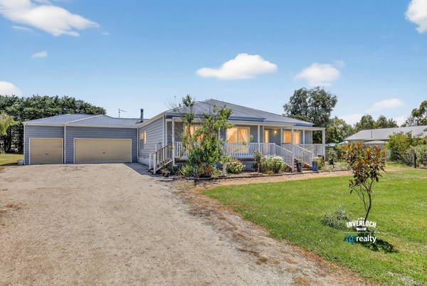 Spacious home with large yard, dual garages, and inviting porches, perfect for outdoor gatherings and relaxation.
