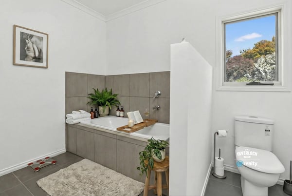 This inviting bathroom features a spacious tub, modern fixtures, and natural light for a refreshing experience.