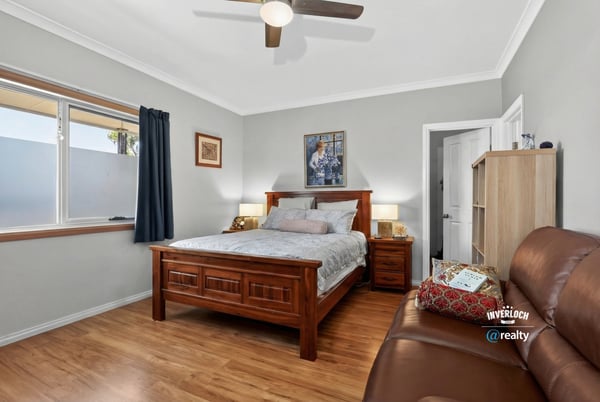 Bright and inviting bedroom featuring natural light, modern furnishings, and a cozy seating area for relaxation.