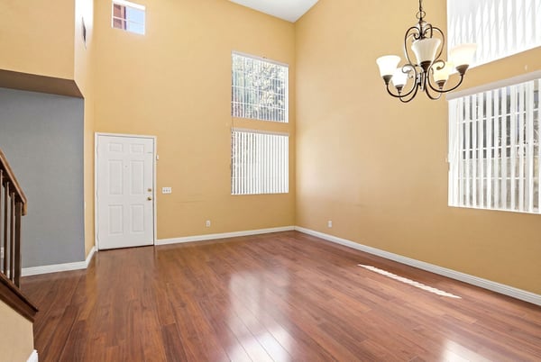 Spacious living area with high ceilings and abundant natural light, perfect for customization and gatherings.