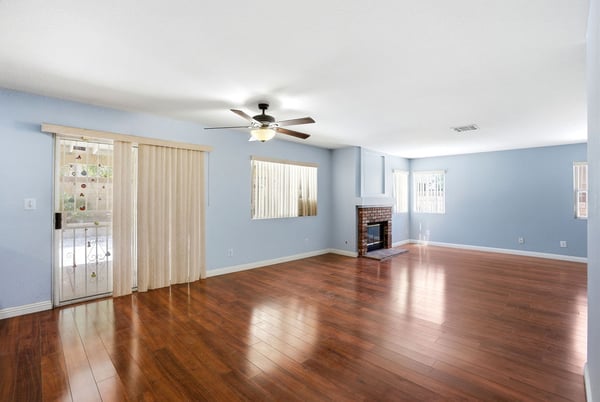 Spacious living area features warm hardwood floors, a cozy fireplace, and abundant natural light.