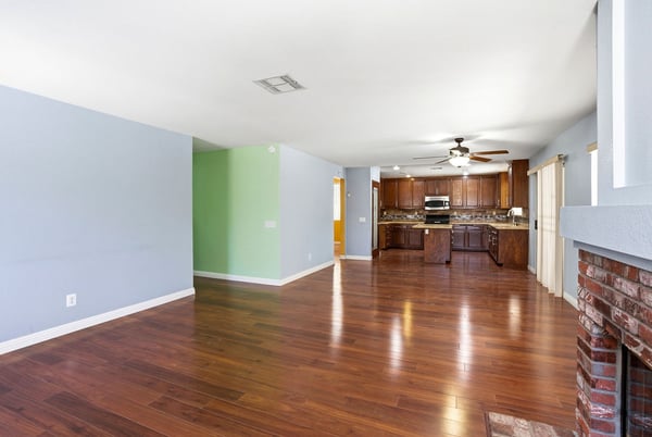 Spacious open-concept living area seamlessly connects kitchen and dining, featuring hardwood floors and natural light.