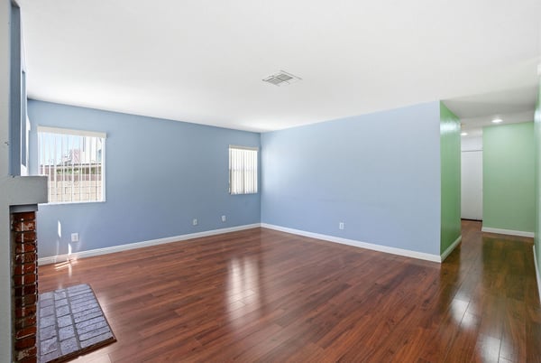 Spacious living area with fresh paint and hardwood floors, perfect for your personal touch and gatherings.