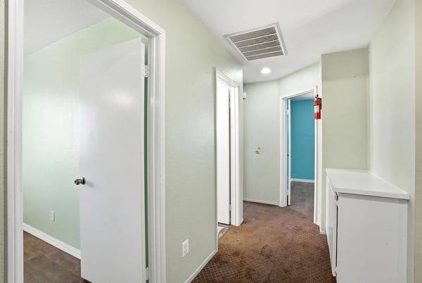 Bright, inviting hallway connects well-sized rooms, featuring fresh paint and unique color accents for a lively atmosphere.