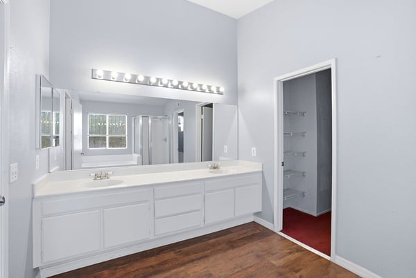 Bright and spacious master bathroom featuring dual vanities, modern lighting, and ample storage options.