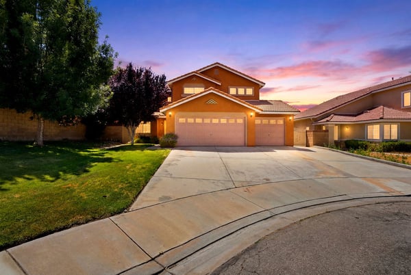 This spacious home features a large driveway and vibrant sunset views in a welcoming neighborhood.