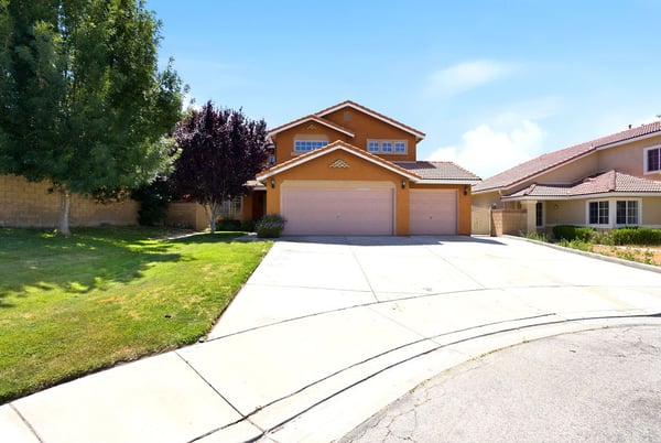 Spacious two-story home with double garage, set on a quiet cul-de-sac surrounded by lush landscaping.