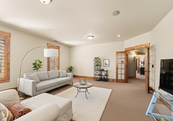 VIRTUAL STAGING. This photo of the Bonus Room has been altered to reflect lighter wall paint and contemporary furnishings.