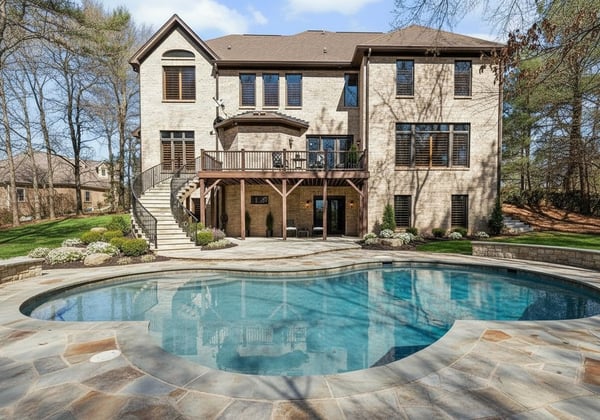 VIRTUALLY STAGED: Staircase from deck, pool with stone surround and landscaping enhance the current grass back yard to reflect the beautiful possibilities for this space.