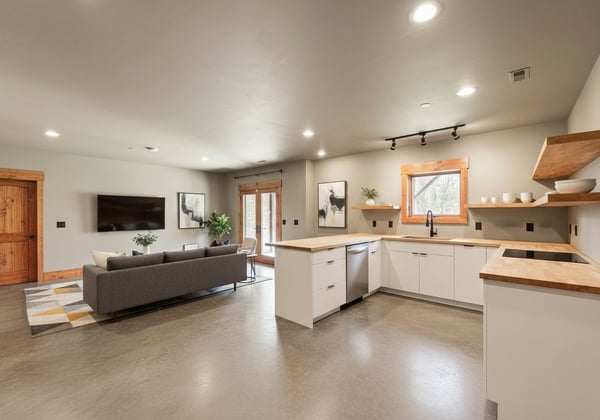 VIRTUAL STAGING: This photo has been enhanced to add kitchen and furnishings to the space. It is currently plumbed for h/c water and additional electrical outlets to support appliances.