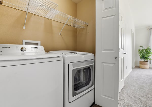 Convenient upstairs laundry featuring modern appliances and convenient shelving for optimal organization and functionality. Washer & dryer included!
