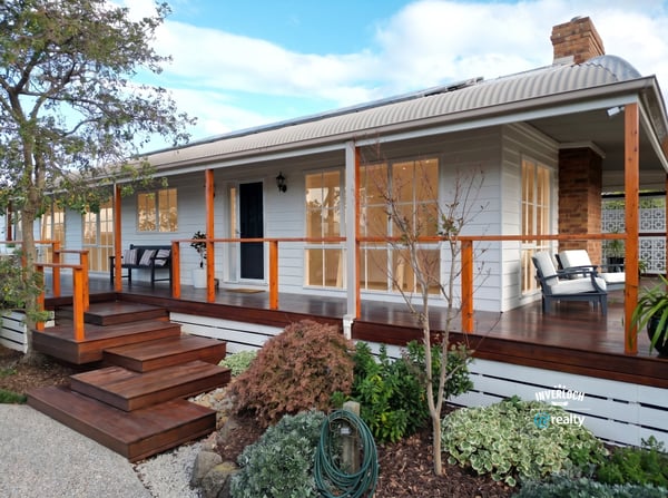 Discover a beautifully designed home featuring a welcoming porch and well-maintained landscaping, perfect for outdoor enjoyment.