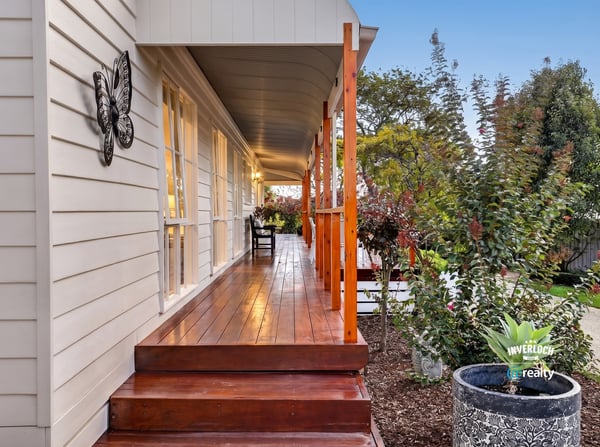 Experience the inviting atmosphere of this well-appointed home with a spacious front porch and lush surroundings.