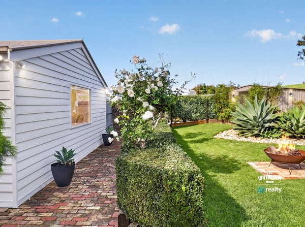 Discover a well-maintained outdoor space featuring lush greenery and a cozy fire pit for gatherings.