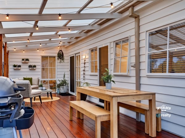 Bright, inviting outdoor space features a dining area and seating, perfect for entertaining year-round.