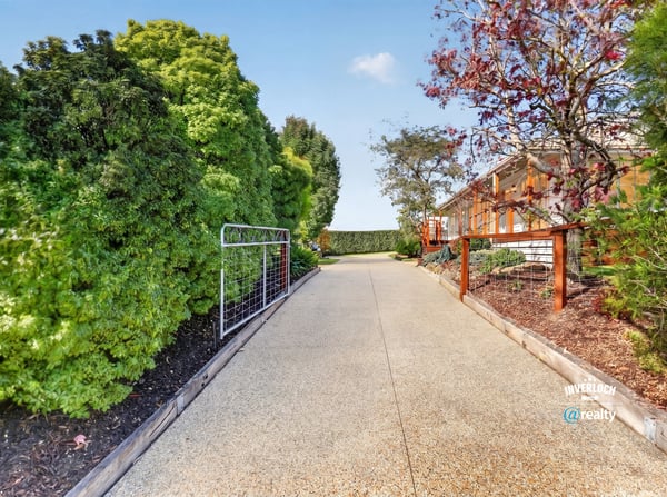 Discover this inviting pathway leading to a beautifully landscaped property, ideal for your future home.