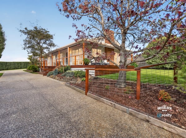 This welcoming home features spacious outdoor areas and a scenic driveway, perfect for family gatherings and relaxation.