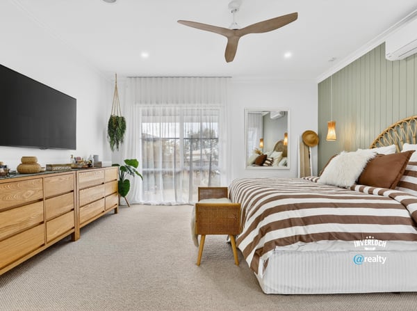 Bright and spacious bedroom featuring natural wood accents, large windows, and modern amenities for comfort.
