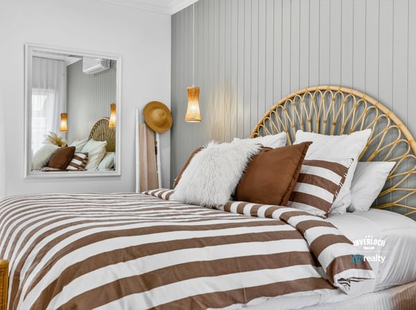 Cozy bedroom featuring a unique headboard, striped bedding, and modern accents for a relaxed atmosphere.
