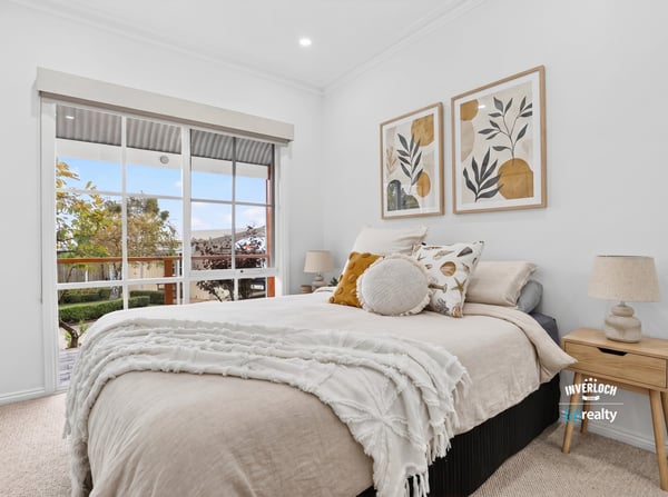 Bright and inviting bedroom featuring large windows, modern decor, and a cozy atmosphere for relaxation.