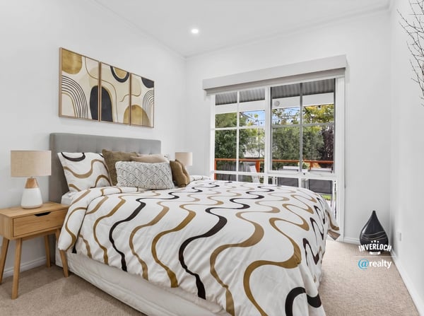 Bright bedroom featuring large windows, modern decor, and a cozy layout, ideal for relaxation and rest.