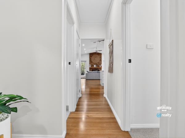 Bright, inviting hallway leading to a spacious living area, showcasing modern design and warmth throughout.