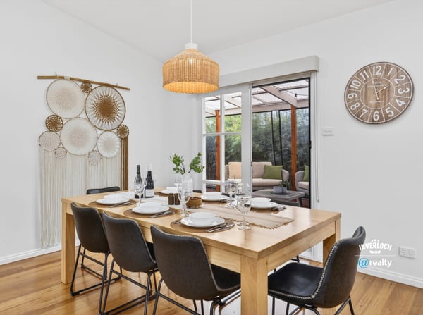 Bright dining area features a spacious table, inviting decor, and views of a cozy outdoor space.