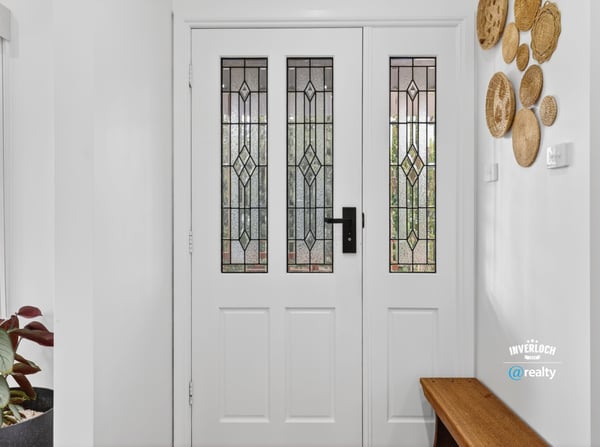 Inviting entryway featuring detailed glass doors and unique wall decor, perfect for welcoming guests.