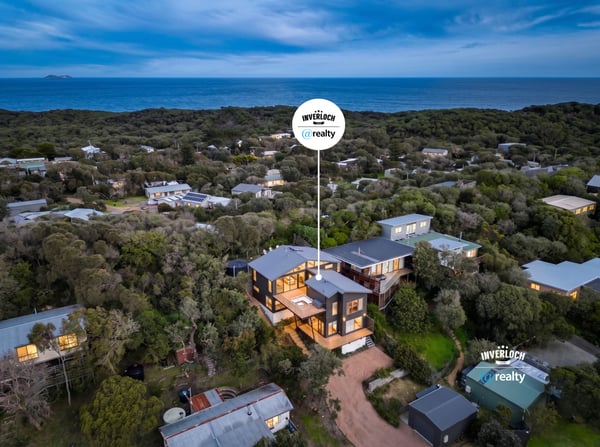 This coastal home offers breathtaking ocean views and modern architecture, nestled among lush greenery.