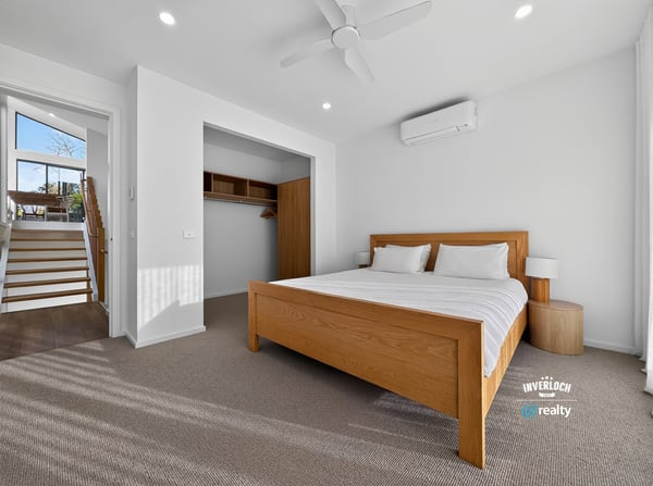 Bright and airy bedroom featuring a spacious layout, modern air conditioning, and abundant natural light.