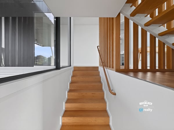 Modern staircase featuring sleek lines and natural light, seamlessly connecting spaces in a contemporary home.