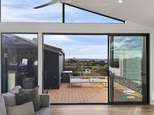 Bright and airy living space opens to a spacious deck, offering stunning views of the landscape.