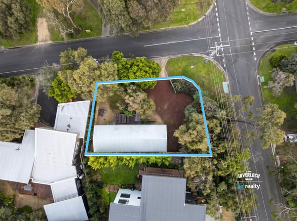 Spacious lot featuring a prime location near a main intersection, surrounded by lush greenery.