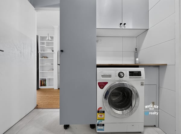 Compact laundry area featuring modern appliances and efficient storage solutions for optimal functionality.
