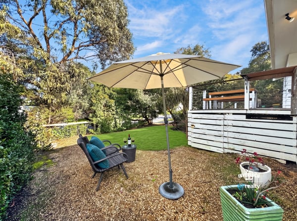 Inviting outdoor space features a shaded seating area, perfect for relaxation or entertaining amid lush greenery.