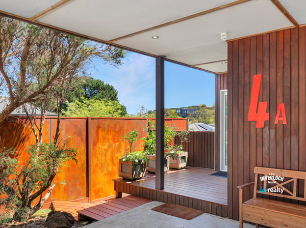 This inviting entry features unique architecture and a vibrant garden area, perfect for welcoming guests.