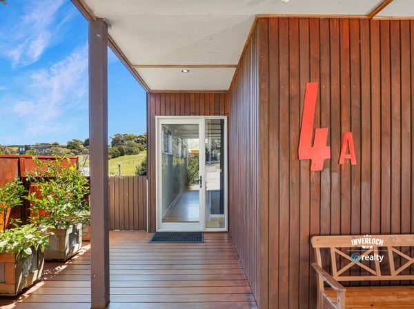 Modern entrance featuring natural wood accents, abundant greenery, and a bright, inviting atmosphere.
