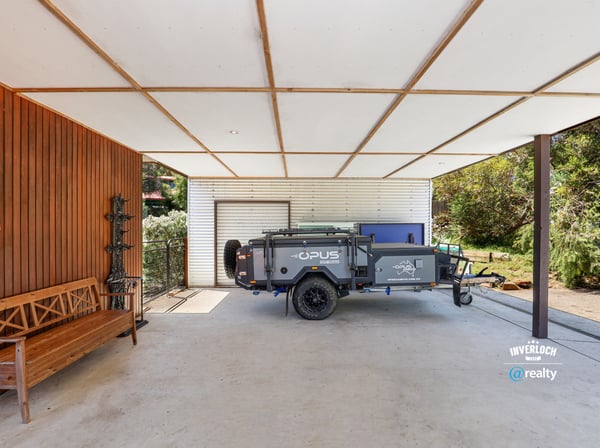Spacious covered area perfect for storage or outdoor activities, featuring a convenient trailer setup.