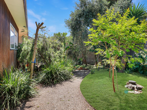 This property features a private garden oasis with lush plants and a peaceful outdoor seating area.