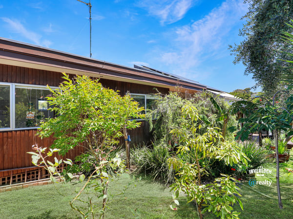 This inviting home features vibrant greenery and spacious outdoor areas, perfect for relaxation and entertainment.