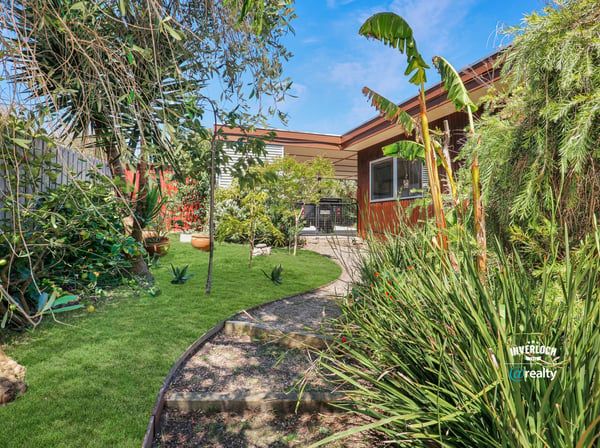 Lush landscaped garden with diverse plants and a cozy patio, perfect for outdoor gatherings and relaxation.