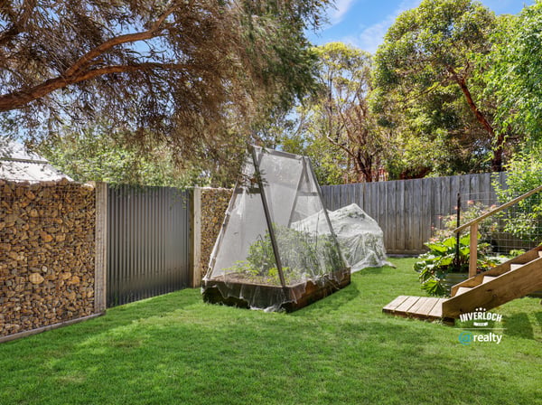 This spacious outdoor area features a productive garden and cozy relaxation spots surrounded by greenery.