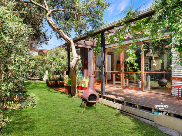 This unique property features a spacious outdoor area with lush greenery and inviting living spaces.