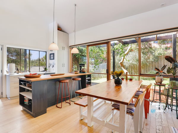Bright and spacious kitchen with large windows, inviting natural light and views of the landscaped yard.