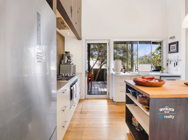 Bright kitchen featuring modern appliances and seamless access to a deck, perfect for entertaining.